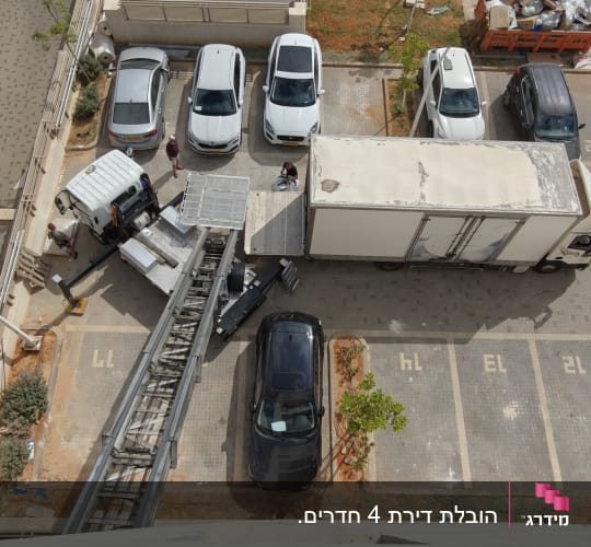 מבט על של משאית הובלה ומנוף הרמה מתוח בבניין מגורים